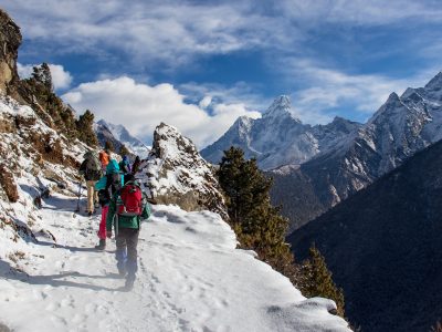 Trekkers hiking through the snow in the Himalayas Trekkers hiking through the snow in the Himalayas